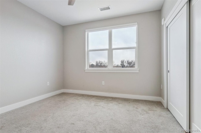 carpeted empty room featuring visible vents and baseboards