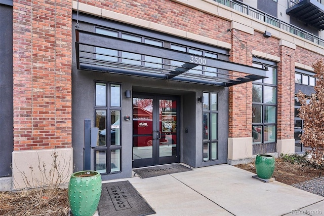 doorway to property featuring french doors and brick siding