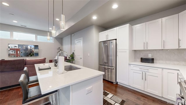 kitchen featuring high quality fridge, white cabinetry, a kitchen bar, and dark hardwood / wood-style floors