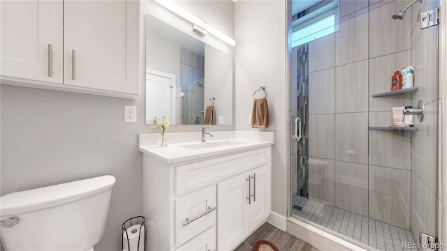 bathroom with walk in shower, vanity, toilet, and hardwood / wood-style flooring