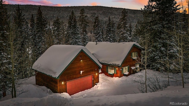 snowy aerial view with a wooded view