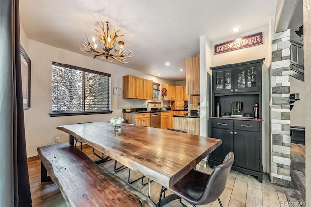 dining space with recessed lighting, light wood-style flooring, baseboards, and an inviting chandelier