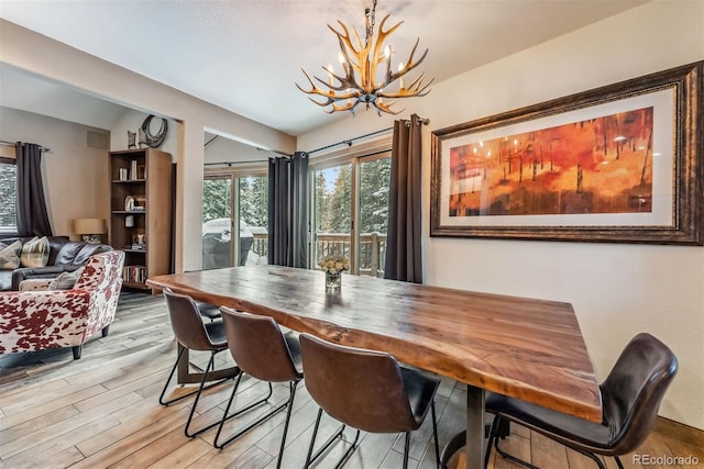 dining space with a chandelier and wood finished floors