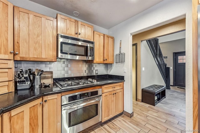 kitchen featuring light wood-style floors, tasteful backsplash, appliances with stainless steel finishes, and light brown cabinetry