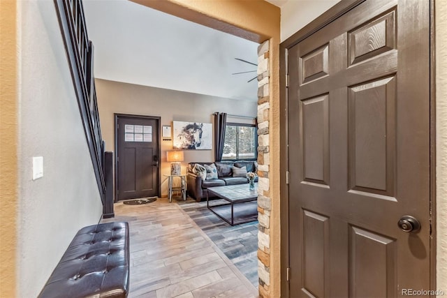 foyer with lofted ceiling, ceiling fan, and wood finished floors