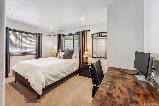 bedroom featuring a textured wall, carpet floors, and recessed lighting