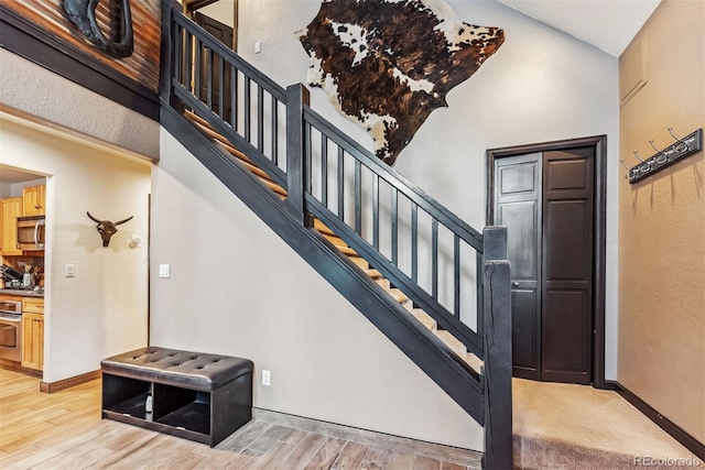 staircase with baseboards and wood finished floors