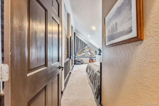 corridor with light carpet and a textured wall