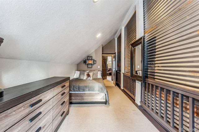 carpeted bedroom with lofted ceiling and a textured ceiling