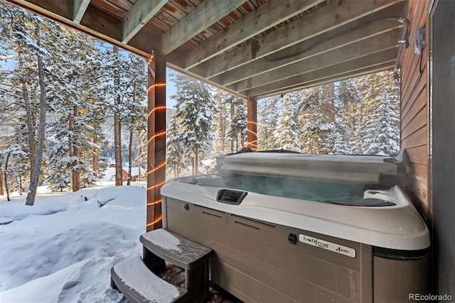 snow covered patio with a hot tub