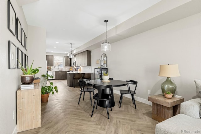 dining space with sink and light parquet flooring