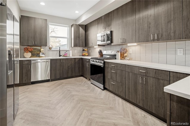 kitchen featuring dark brown cabinetry, backsplash, sink, and appliances with stainless steel finishes