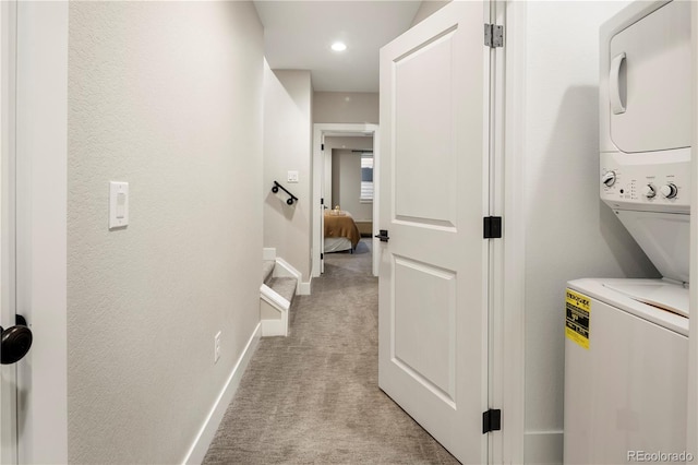 laundry area with light carpet and stacked washer and dryer