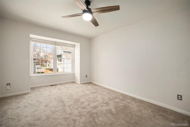 empty room featuring baseboards, a ceiling fan, visible vents, and carpet floors