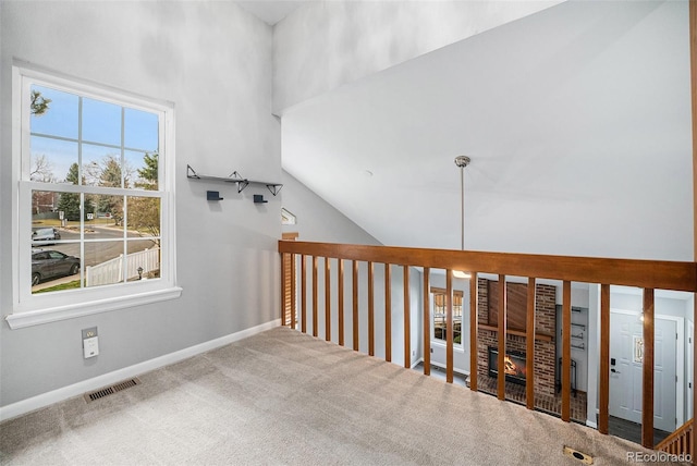 corridor with carpet, visible vents, and baseboards