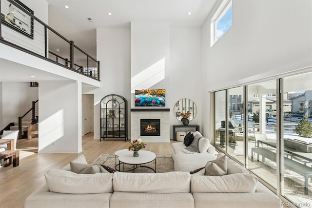 living room with a tile fireplace and light hardwood / wood-style floors