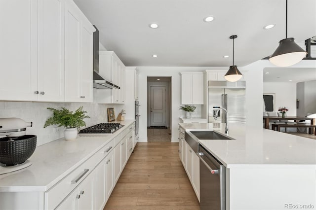 kitchen with sink, decorative light fixtures, white cabinets, and appliances with stainless steel finishes