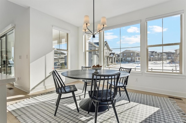 dining area featuring hardwood / wood-style floors and a notable chandelier