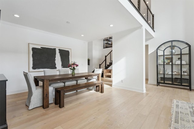 dining space with crown molding and light hardwood / wood-style flooring