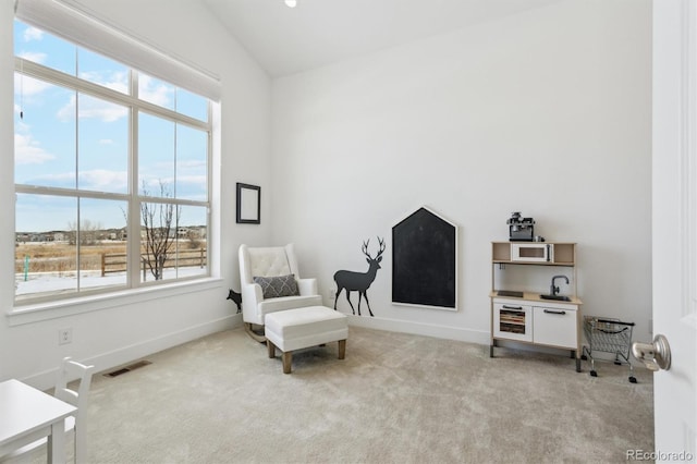 sitting room with light carpet and lofted ceiling