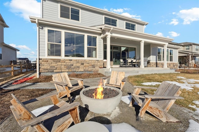 rear view of property with an outdoor fire pit and a patio area