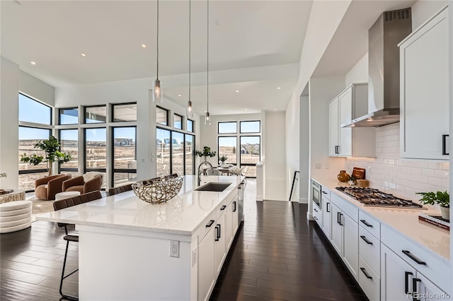 8648 Carneros Ct, Parker, CO 80138 - kitchen with wall chimney range hood, open floor plan, stainless steel appliances, plenty of natural light, and recessed lighting