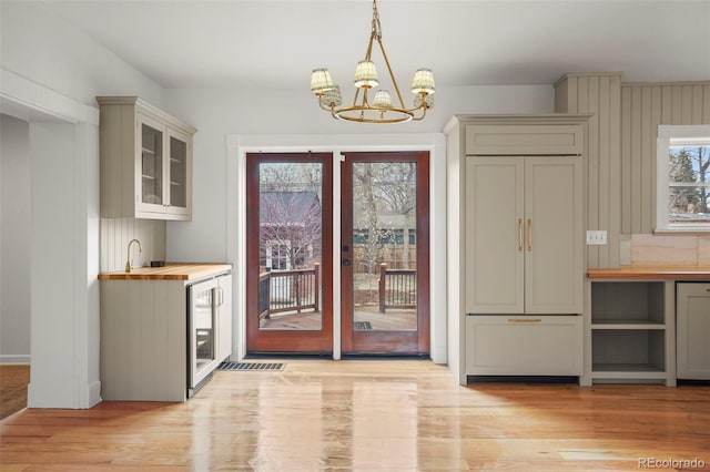 841 Niagara St, Denver, CO 80220 - doorway to outside featuring beverage cooler, wet bar, a notable chandelier, and light wood-style floors