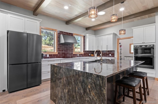 25350 Ridge Way, Golden, CO 80401 - kitchen with black appliances, a sink, under cabinet range hood, light wood-style floors, and tasteful backsplash