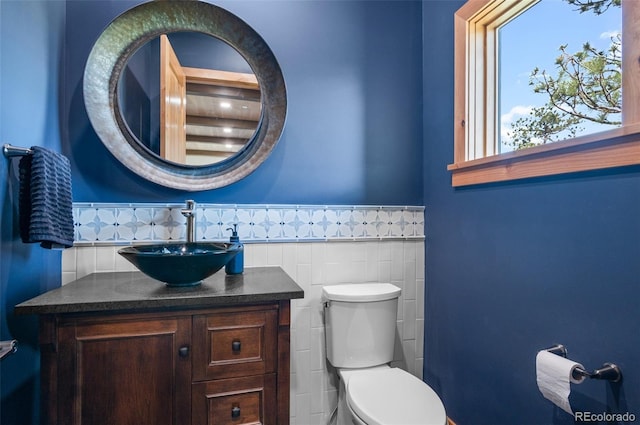25350 Ridge Way, Golden, CO 80401 - bathroom with vanity, toilet, tile walls, and a wainscoted wall