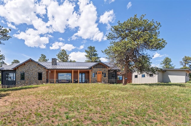 25350 Ridge Way, Golden, CO 80401 - rear view of property featuring a standing seam roof, stone siding, a lawn, metal roof, and a chimney