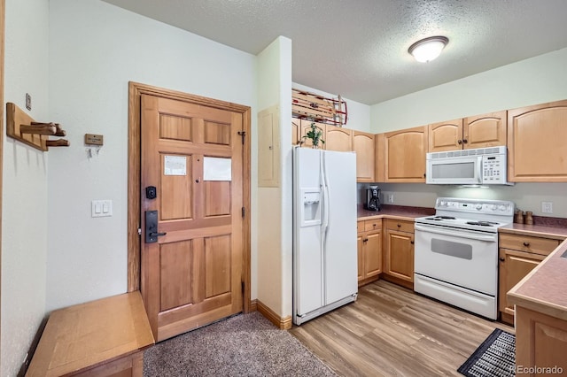 22714 US Highway 6 Unit 5945, Keystone, CO 80435 - kitchen featuring white appliances, light wood-type flooring, light brown cabinets, a textured ceiling, and light countertops