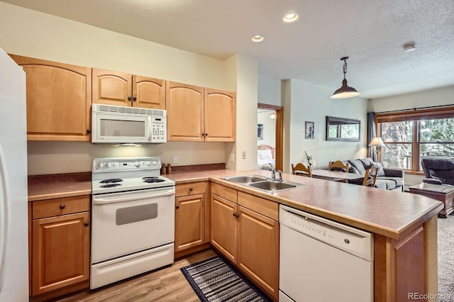 22714 US Highway 6 Unit 5945, Keystone, CO 80435 - kitchen featuring white appliances, a peninsula, light wood finished floors, open floor plan, and light brown cabinetry