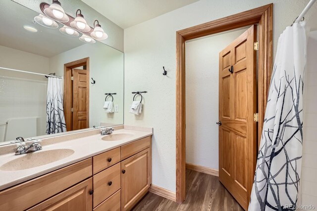 22714 US Highway 6 Unit 5945, Keystone, CO 80435 - full bathroom featuring wood finished floors, double vanity, and a shower with curtain