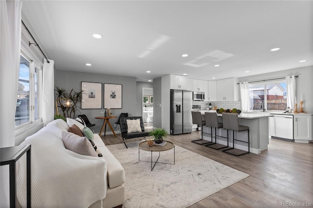 living room with sink and light hardwood / wood-style floors