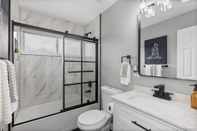 full bathroom featuring vanity, toilet, and combined bath / shower with glass door