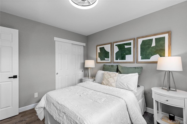 bedroom with dark hardwood / wood-style flooring and a closet