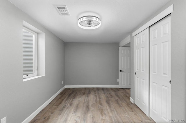 unfurnished bedroom featuring light hardwood / wood-style flooring and a closet