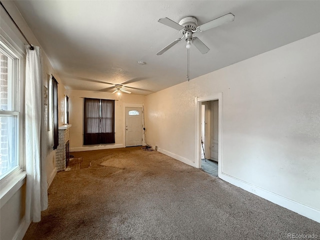 unfurnished living room featuring carpet, baseboards, and ceiling fan