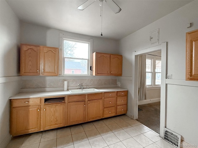 kitchen with visible vents, light countertops, ceiling fan, and a sink