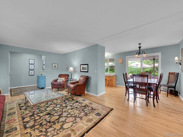 595 W Lake Ave, Littleton, CO 80120 - living area with light wood finished floors, a chandelier, and baseboards