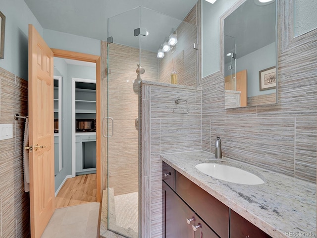 595 W Lake Ave, Littleton, CO 80120 - full bath with vanity, a shower stall, and tile walls