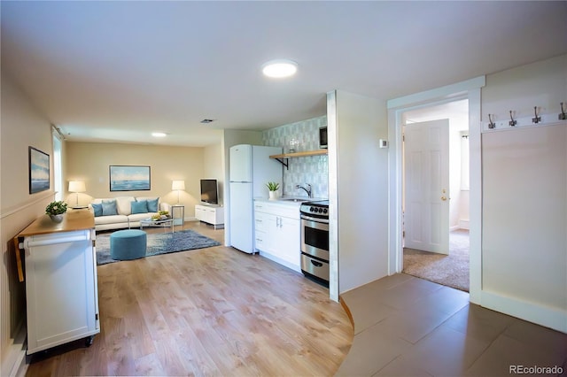 2507 9th St, Boulder, CO 80304 - kitchen with stainless steel stove, freestanding refrigerator, white cabinetry, open shelves, and open floor plan