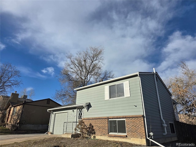 exterior space featuring an attached garage, brick siding, and driveway