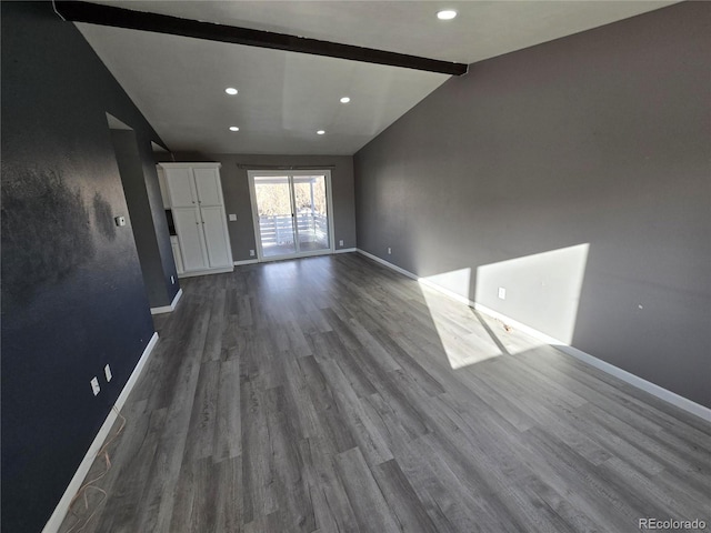 unfurnished living room featuring dark wood-style floors, recessed lighting, lofted ceiling with beams, and baseboards