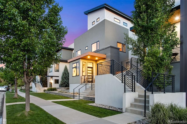 357 Pascal St, Fort Collins, CO 80524 - contemporary home featuring stucco siding, a lawn, and stairs