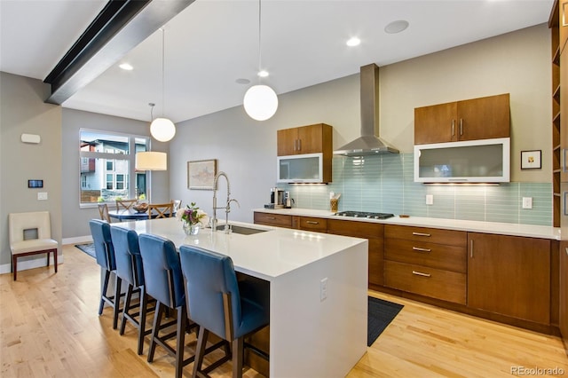 357 Pascal St, Fort Collins, CO 80524 - kitchen featuring wall chimney range hood, brown cabinets, stainless steel gas stovetop, light wood finished floors, and recessed lighting