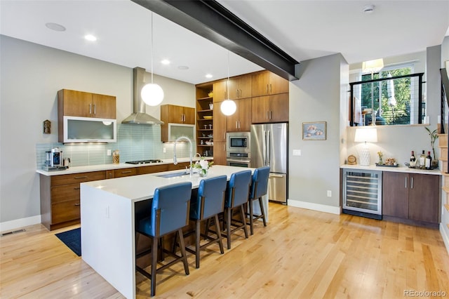 357 Pascal St, Fort Collins, CO 80524 - kitchen with wine cooler, stainless steel appliances, wall chimney range hood, a sink, and brown cabinets