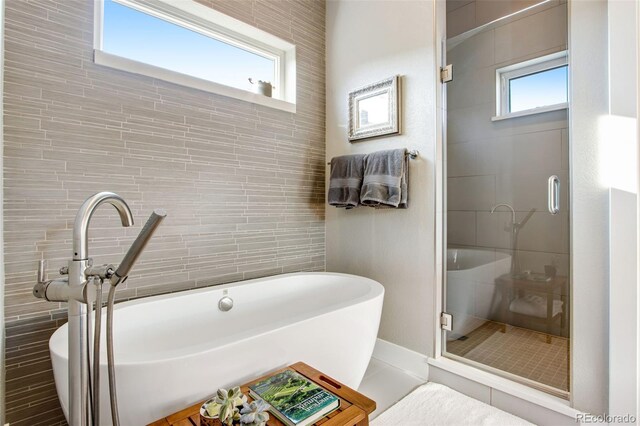 357 Pascal St, Fort Collins, CO 80524 - full bathroom with tile walls, a soaking tub, and a shower stall