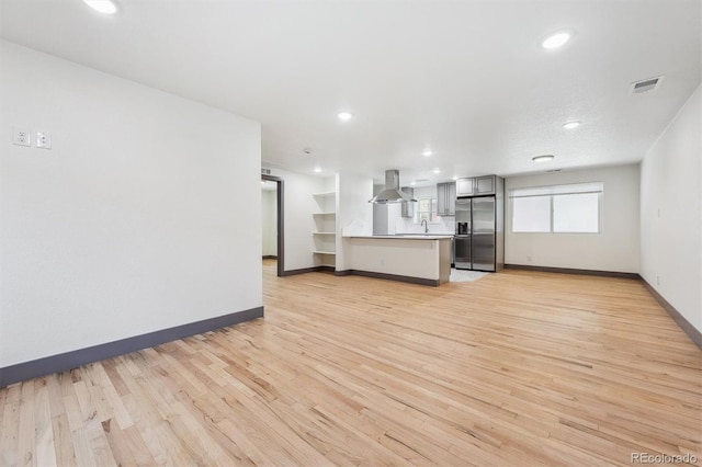 1112-11121/2 Krameria St, Denver, CO 80220 - unfurnished living room with light wood-style floors and recessed lighting
