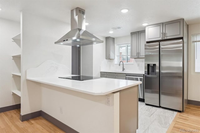 1112-11121/2 Krameria St, Denver, CO 80220 - kitchen with island range hood, appliances with stainless steel finishes, gray cabinetry, and a peninsula